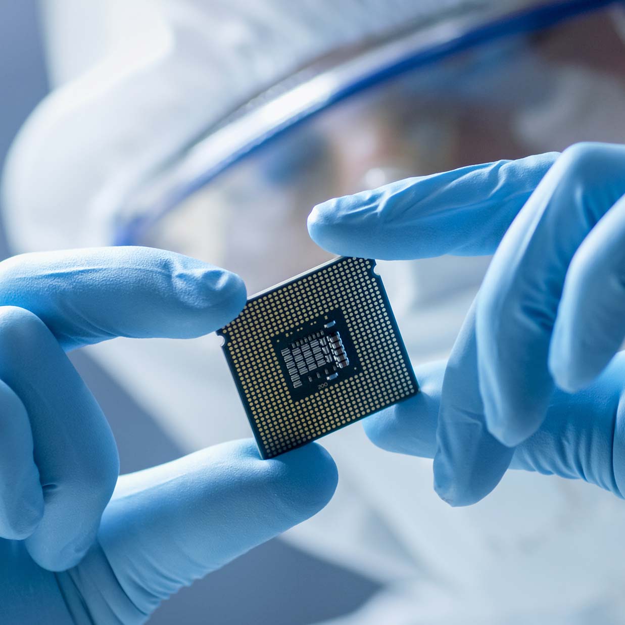 A employee wearing a clean room suit (also known as a bunny suit) inspecting a CPU