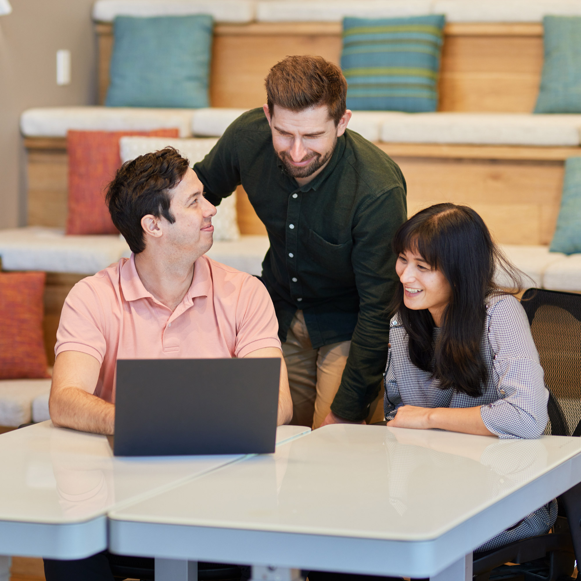 Three co-workers looking at information displayed on a computer monitor.