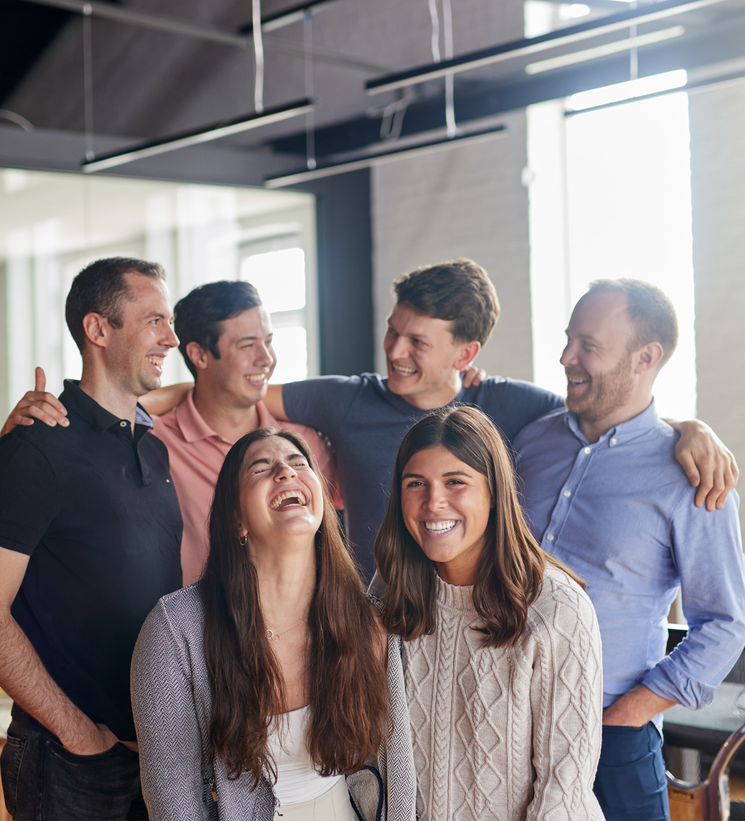Three Co-workers celebrating around a table.